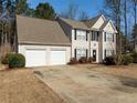 Two-story house with beige siding, a two-car garage, and a landscaped yard at 3408 Sandlake Dr, Marietta, GA 30008