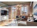 Bright living room with exposed brick, large windows, and comfortable seating at 3235 Roswell Ne Rd # 615, Atlanta, GA 30305