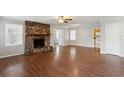 Living room with hardwood floors, stone fireplace, and ceiling fan at 1058 Hickory Rd, Canton, GA 30115