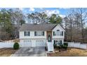 Charming two-story home with a two-car garage and a welcoming entrance with white stairs and a landscaped yard at 1620 Cedar Hl, Douglasville, GA 30134