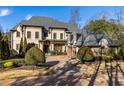 Elegant two-story house with a three-car garage and lush greenery at 1696 Windsor Ne Pkwy, Atlanta, GA 30319