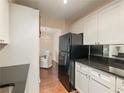 Clean kitchen with black appliances, white cabinets, and dark countertops next to a dining room space at 2479 Peachtree Ne Rd # 407, Atlanta, GA 30305