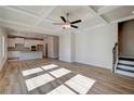 Bright, open-concept living space with hardwood floors and coffered ceiling at 414 Westmarch Cir, Loganville, GA 30052