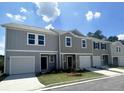 Three townhouses with gray siding and white garage doors at 302 Hynes Sw Dr, Villa Rica, GA 30180