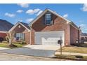 Brick ranch house with attached garage and manicured lawn at 215 Prominent Loop, Mcdonough, GA 30253