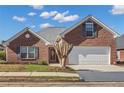 Brick ranch house with attached garage and manicured lawn at 215 Prominent Loop, Mcdonough, GA 30253