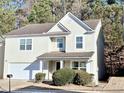 Two-story house with light beige siding, a double garage, and manicured landscaping at 4534 Parkway Cir, Atlanta, GA 30349