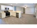 Modern eat-in kitchen with white cabinets, stainless steel appliances, and wood-look tile floors at 4534 Parkway Cir, Atlanta, GA 30349