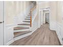Bright foyer with hardwood floors, staircase, and wainscoting at 3944 Howell Park Rd, Duluth, GA 30096