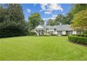 Spacious home with a large front yard and lush landscaping at 5915 Riverwood Dr, Atlanta, GA 30328