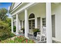 Elegant front porch with columns, rocking chairs, and beautiful landscaping at 5915 Riverwood Dr, Atlanta, GA 30328
