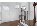 Bright entryway features a white paneled door, wood floors, and a stylish console table with a round mirror above at 840 Regal Ln, Atlanta, GA 30331