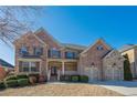 Two story brick home with three-car garage and landscaped yard at 1828 Austins Pointe Dr, Lawrenceville, GA 30043