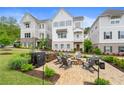 Attractive two-story townhouse with a brick patio, fire pit, and lounge seating surrounded by manicured landscaping at 396 Silverbell Way, Marietta, GA 30060