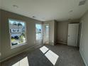 A modern, light-filled room with carpet and a window that offers plenty of natural light at 110 Okeechobee Way, Braselton, GA 30548