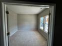A modern, light-filled room with carpet and a window that offers plenty of natural light at 110 Okeechobee Way, Braselton, GA 30548