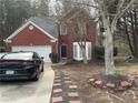 Charming two-story red brick home with bay window, black door, and a patterned walkway to the entrance at 175 Lazy Willow Ln, Lawrenceville, GA 30044