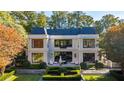 Backyard view of an elegant home with manicured gardens and patio seating perfect for outdoor entertaining and relaxation at 133 Blackland Nw Rd, Atlanta, GA 30342