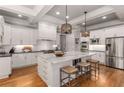 Modern kitchen with white cabinets, large island, and stainless steel appliances at 4545 Whitestone Way, Suwanee, GA 30024