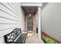 Inviting front porch with stone accents, a decorative wreath, and a cozy bench at 319 Pinewood Dr, Woodstock, GA 30189