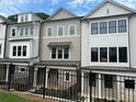 View of new townhomes with brick and siding, featuring multiple windows, and black metal fence at 1980 Flying Scotsman Dr # 10, Kennesaw, GA 30144