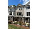 View of newly built townhomes features white siding and stone accents with dark metal railings and black windows at 1980 Flying Scotsman Dr # 10, Kennesaw, GA 30144