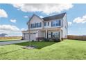 Two-story house with a neutral color scheme, two car garage, and landscaped lawn at 727 Coneflower Way, Mcdonough, GA 30253