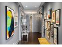 Long hallway with gray walls, hardwood floors, and gallery-style art display at 2660 Peachtree Rd # 27E, Atlanta, GA 30305