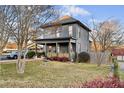 Gray house with a wraparound porch, mature trees, and a manicured lawn at 679 N Central Ave, Hapeville, GA 30354