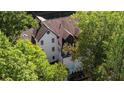 Aerial view of a white house with dark accents, surrounded by tall trees at 6305 River Chase Cir, Atlanta, GA 30328