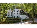 White two-story house with a modern design, surrounded by trees and landscaping at 6305 River Chase Cir, Atlanta, GA 30328