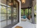 Inviting porch with a fireplace, stylish seating, and French doors leading inside at 6305 River Chase Cir, Atlanta, GA 30328