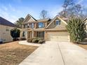 Two-story house with brick and siding, attached garage, and manicured landscaping at 7227 Parks Trl, Fairburn, GA 30213