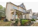 Side view of a two-story home featuring a covered porch and manicured landscaping at 2496 Osceola Rd, Lithonia, GA 30058