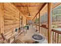 Spacious back porch with a fire pit and wooden seating at 135 Fiddle Crk, Social Circle, GA 30025