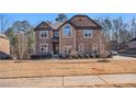 Stately two-story brick home with an arched window, well-kept lawn, and mature landscaping at 2625 Lake Erma Dr, Hampton, GA 30228