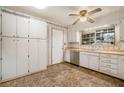 Bright kitchen with white cabinets, stainless steel dishwasher, and vinyl flooring at 3310 Chisholm Sw Trl, Marietta, GA 30060