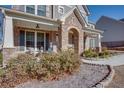 Brick front porch with stone columns and seating area at 5015 Montes Ln, Cumming, GA 30040