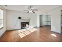 Living room with hardwood floors, fireplace, and ceiling fan at 6738 Merrywood Dr, Fairburn, GA 30213