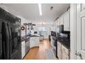 Modern kitchen with white cabinets, black countertops, and stainless steel appliances at 1809 Francon Sw Ct, Conyers, GA 30094