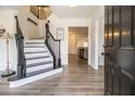 Bright entryway with a grand staircase, dark wood railings, and luxury vinyl plank flooring at 537 N Cedar N Ct, Riverdale, GA 30274