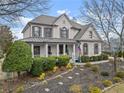 Beautiful two-story home boasting a covered front porch, gray shutters, and meticulous landscaping at 6310 Fox Creek Dr, Cumming, GA 30040