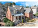 Brick home with stone accents, a large front porch, and a landscaped yard at 2976 Cambridge Hill Dr, Dacula, GA 30019