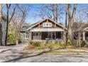 Craftsman home featuring a welcoming front porch, with gray brick and manicured landscaping at 1316 North Ne Ave, Atlanta, GA 30307