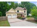 Two-story house with a long driveway, two-car garage, and landscaped yard at 2010 Sturbridge Ln, Buford, GA 30519