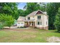 Two-story house with a spacious yard and attached garage, nestled among lush trees at 2010 Sturbridge Ln, Buford, GA 30519