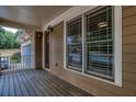Spacious front porch with wood flooring, side entrance door, and charming outdoor lighting at 101 Chestnut Dr, Canton, GA 30114