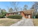 Brick home with a covered carport, green lawn, and classic design elements at 1820 Arkose Dr, Atlanta, GA 30316