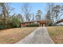 Well-kept brick home with a carport and established landscaping along a concrete driveway at 1820 Arkose Dr, Atlanta, GA 30316