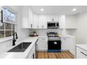 Modern kitchen boasts stainless steel appliances, white cabinets, and sleek countertops at 556 Rivercrest Dr, Woodstock, GA 30188